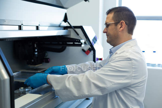 Homme scientifique utilisant une machine en laboratoire — Photo de stock