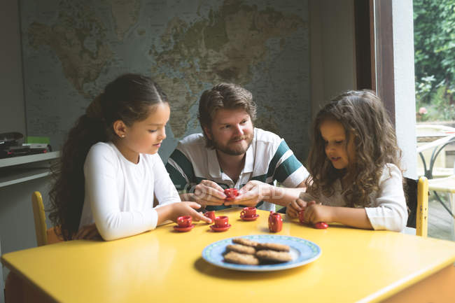 Father with his daughters playing with toys at home — Stock Photo