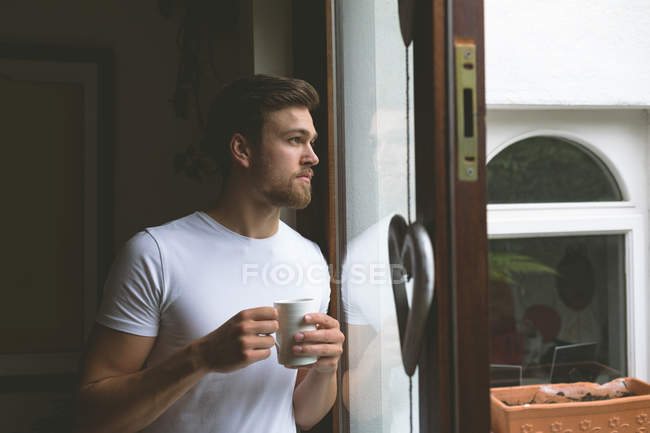Удумливий чоловік має каву вдома — стокове фото