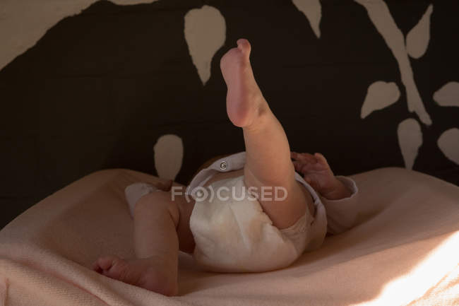 Bebê relaxante em cama de bebê em casa — Fotografia de Stock