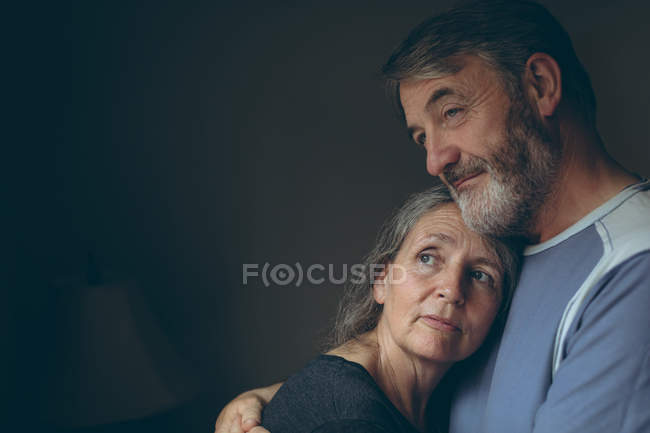 Romântico casal sênior abraçando uns aos outros em casa — Fotografia de Stock