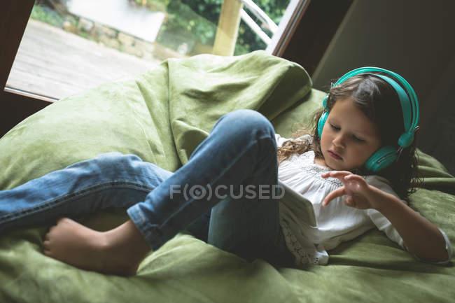 Дівчина слухає музику, використовуючи цифровий планшет вдома — стокове фото