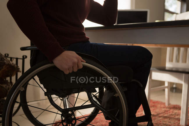 Средняя часть инвалида в инвалидной коляске на дому — стоковое фото