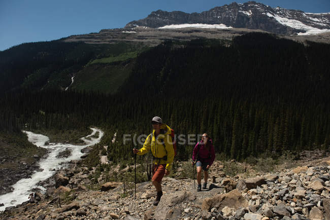 Caminhadas de casal nas montanhas em um dia ensolarado — Fotografia de Stock