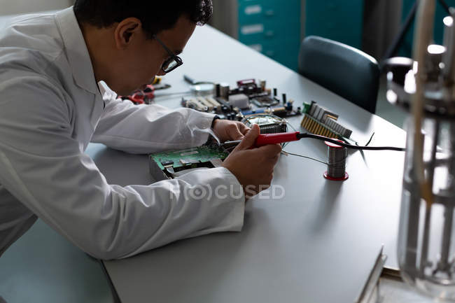 Cientista do sexo masculino experimentando em placa de circuito em laboratório — Fotografia de Stock