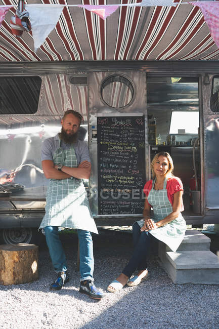 Пара розслабляється біля їжі вантажівка в сонячний день — стокове фото