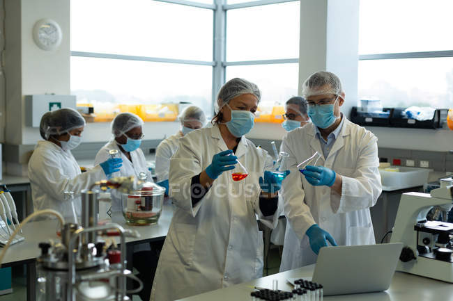 Scientists experimenting together in laboratory — Stock Photo