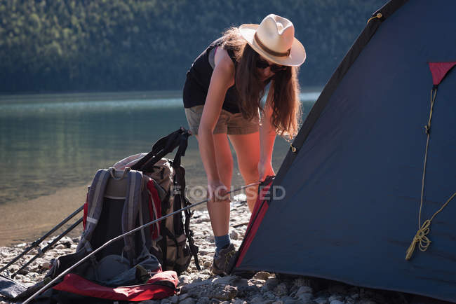 Femme installant tente par une journée ensoleillée — Photo de stock