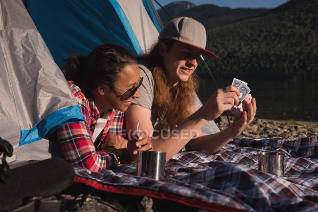 Couple playing with playing cards in tent — Stock Photo