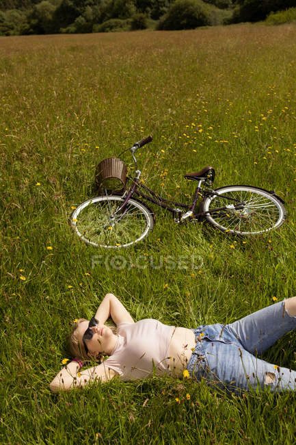 Giovane donna rilassante sul campo — Foto stock