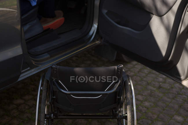 Primer plano de la silla de ruedas y el coche - foto de stock