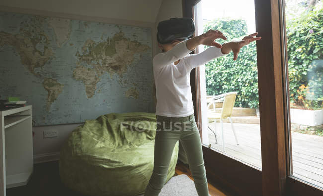 Дівчина використовує гарнітуру віртуальної реальності у вітальні вдома — стокове фото
