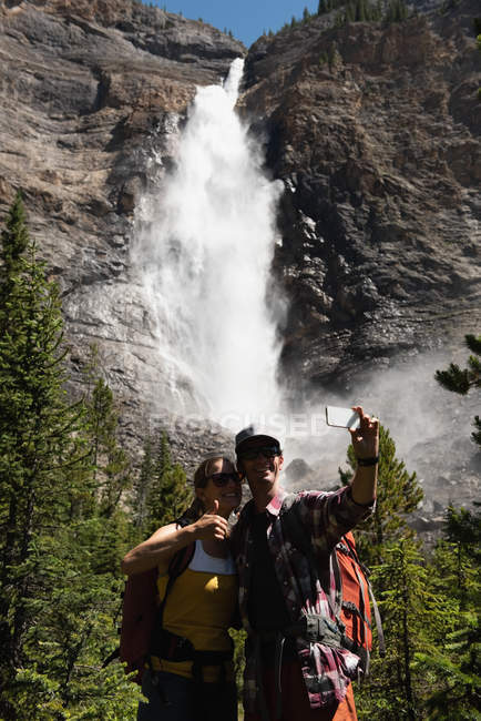 Couple prenant selfie avec téléphone portable en montagne — Photo de stock