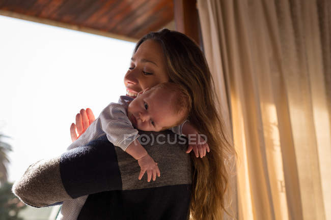 Felice madre che tiene il suo bambino a casa — Foto stock