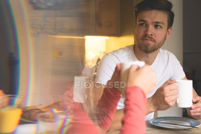 Couple interacting with each other while having coffee at home — Stock Photo
