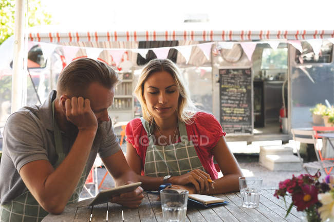 Молодая пара работает вместе в кафе на открытом воздухе — стоковое фото