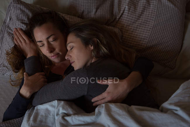 Lesbian couple relaxing on bed at home — Stock Photo