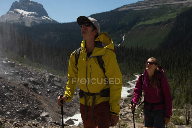 Caminhadas de casal nas montanhas em um dia ensolarado — Fotografia de Stock
