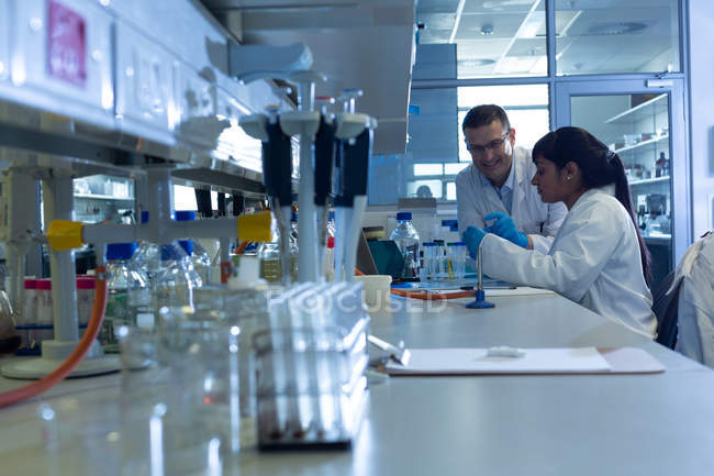 Cientistas experimentando juntos em laboratório — Fotografia de Stock