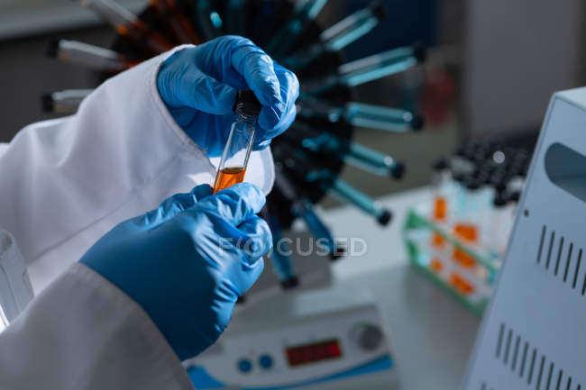 Cientista feminina examinando tubo de ensaio em laboratório — Fotografia de Stock