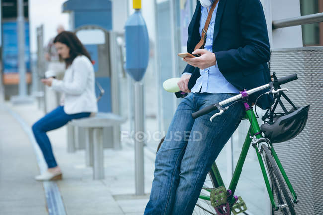 Mid section of businessman using mobile phone at railway station — Stock Photo