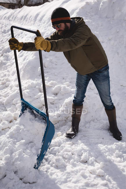 Homem limpando neve com empurrador de neve durante o inverno — Fotografia de Stock