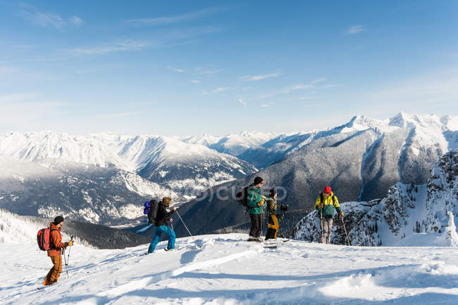 Группа лыжников, стоящих на снежной горе зимой — стоковое фото