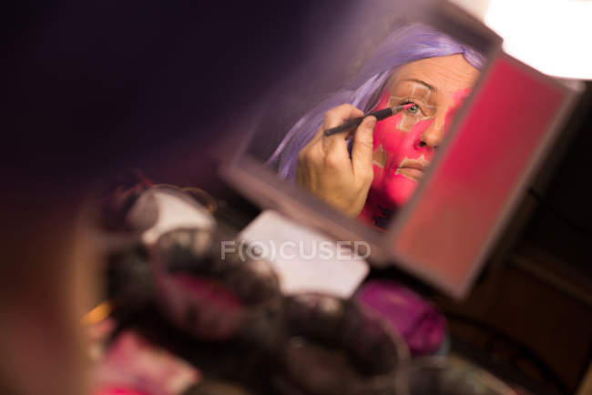 Mulher pintando seu rosto com escova para a celebração do dia das bruxas — Fotografia de Stock