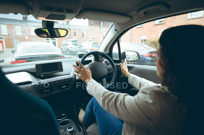 Businesswoman driving a car in the city — Stock Photo