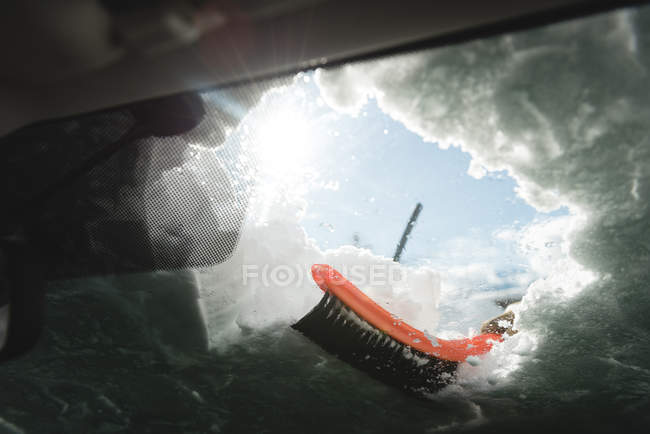 Snow being cleared from car windshield during winter — Stock Photo