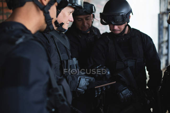 Военные обсуждают свой план за цифровым планшетом во время военной подготовки — стоковое фото