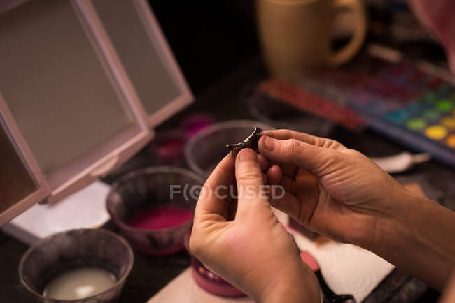 Close-up of woman holding artificial eye lashes — Stock Photo