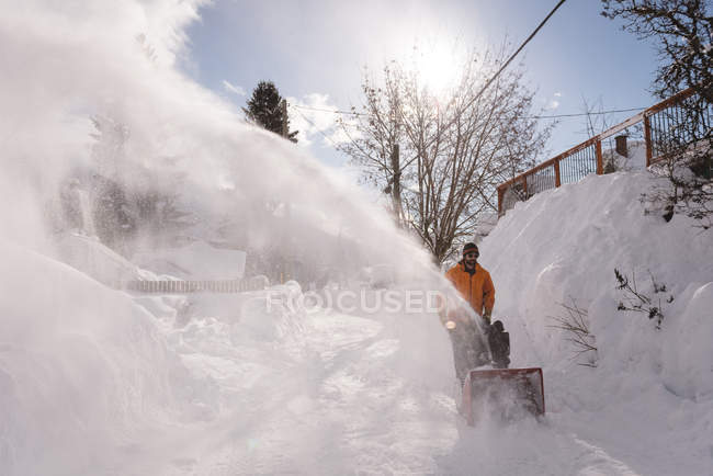 Man using snow blower machine in snowy region during winter — Stock Photo
