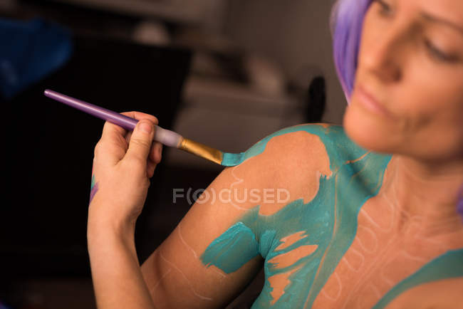 Mulher pintando seu corpo para a celebração do dia das bruxas — Fotografia de Stock