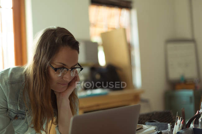 Designer de jóias feminino usando laptop em casa — Fotografia de Stock