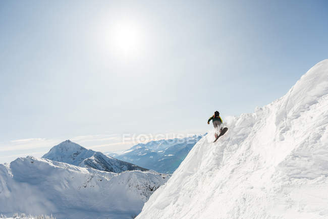 Esquiador esquiando en una montaña nevada durante el invierno - foto de stock