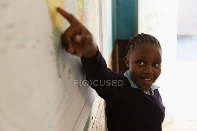 Estudante explicando sobre mapa do mundo em sala de aula na escola — Fotografia de Stock