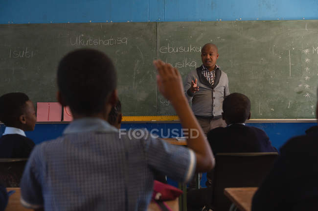 Professora do sexo masculino ensinando alunos na turma na escola — Fotografia de Stock