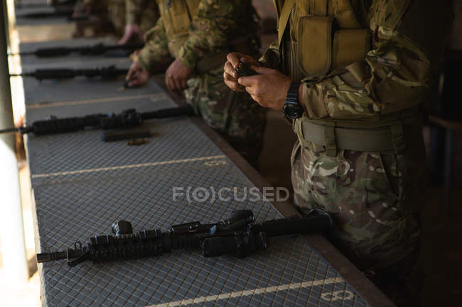 Military soldiers loading bullets in magazine during military training — Stock Photo