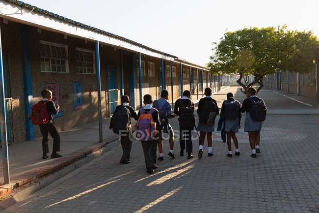 Школьники, гуляющие в школьном городке в солнечный день — стоковое фото