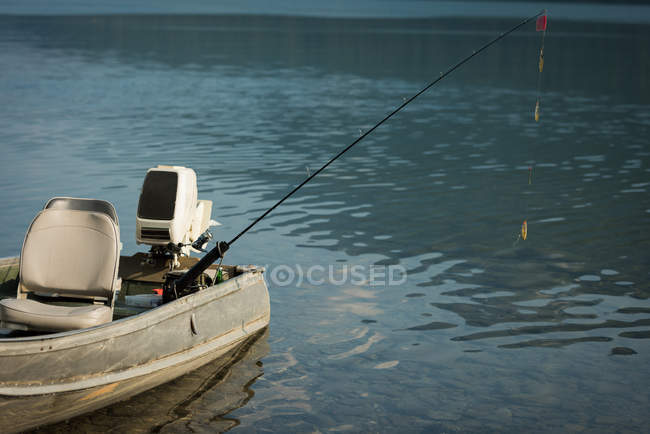 Моторний човен з рибальським стрижнем на річці — стокове фото