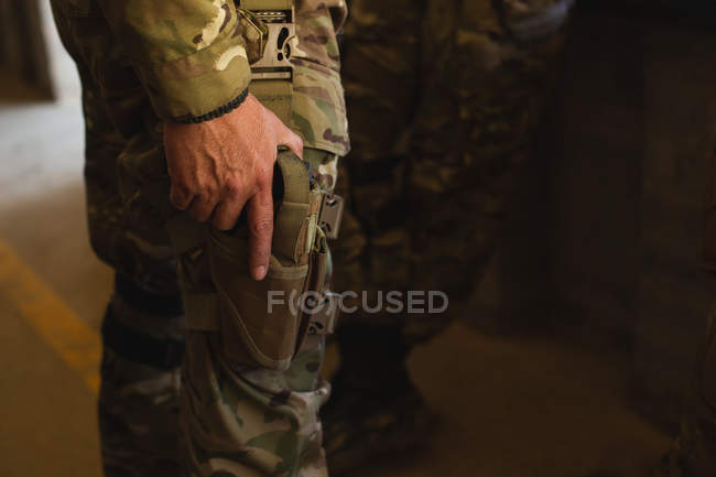 Partie médiane du soldat militaire debout avec un pistolet pendant l'entraînement militaire — Photo de stock