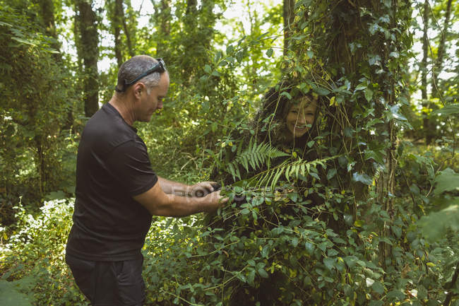 Mann rettet Frau, die in Gebüsch im Wald steckt — Stockfoto