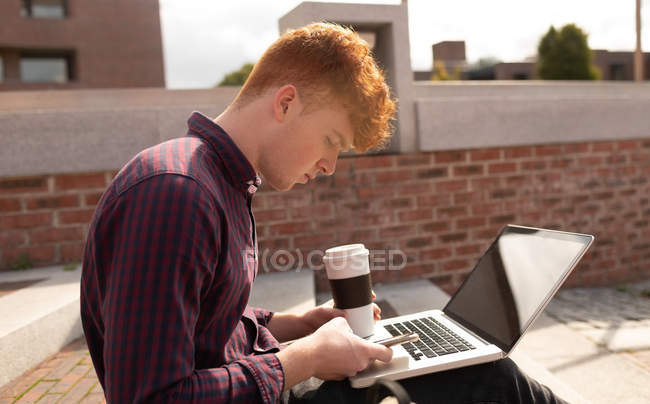 College student using mobile phone on stairs in college — Stock Photo