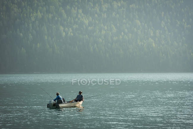 Deux pêcheurs pêchent dans la rivière par une journée ensoleillée — Photo de stock