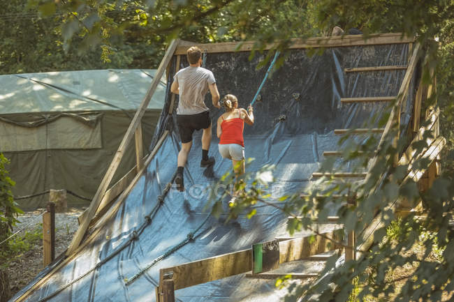 Чоловік і жінка тренуються над перешкодами в таборі для завантаження — стокове фото
