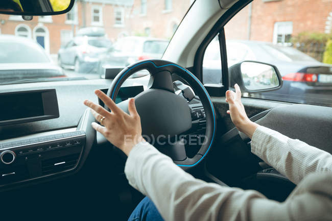 Mid section of businesswoman driving a car — Stock Photo