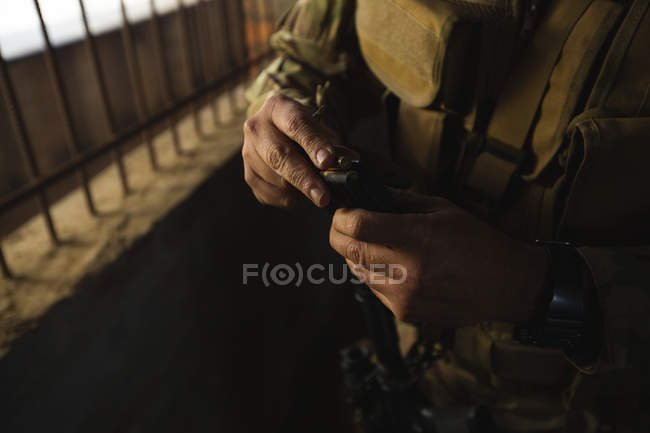 Военные солдаты заряжают пули в склад во время военной подготовки — стоковое фото