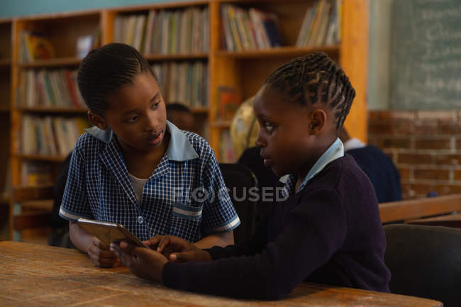 Crianças em idade escolar usando tablet digital em sala de aula na escola — Fotografia de Stock