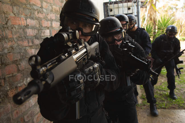 Soldados militares com rifle andando contra a parede durante o treinamento militar — Fotografia de Stock